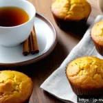 항염증 식단을 위한 베이킹 아이디어 - A warm and inviting kitchen scene featuring a freshly baked batch of golden turmeric muffins on a ru...